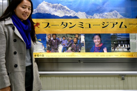 Ms. Sonam Choki with the poster featuring her photograph, taken 9 years ago. The poster is in an underground walkway in Fukui City.