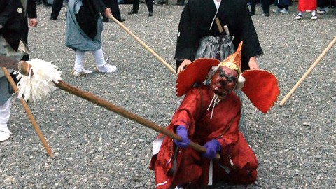 The dancer with Tengu long-nosed goblin mask and a bird-shaped hat holding a pike