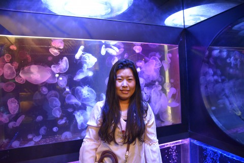 Mr.Ugyen Dorji's sister is standing in front of jellyfish tanks