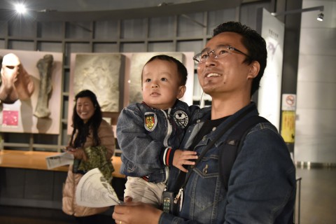 Mr. Ugyen Dorji and his son are getting impressed by a large moving dinosaur