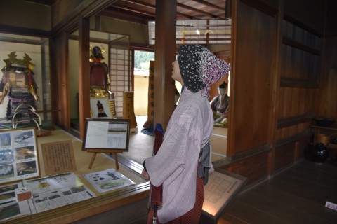 A staff is explaining about things in the restored house