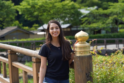 Julia is smiling and standing on the bridge