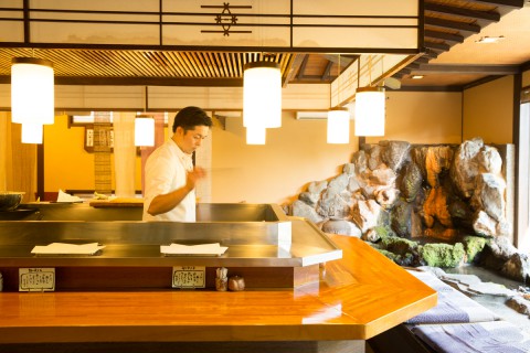 a cook is making tempura in the middle of the restaurant