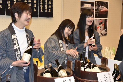 three smiling women are serving sake 