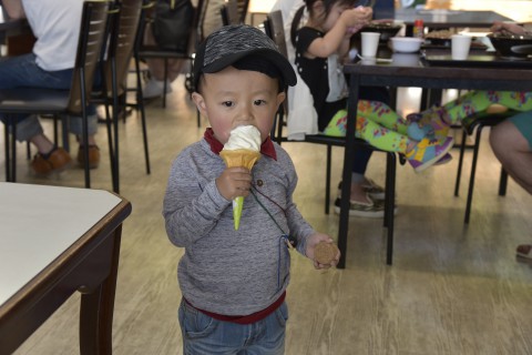 a 2 years old boy from Bhutan is eating a soft serve ice cream