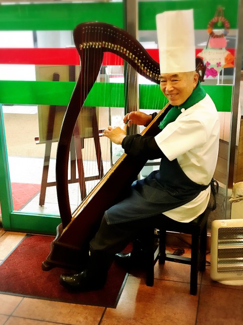 chef holding and sitting with his harp