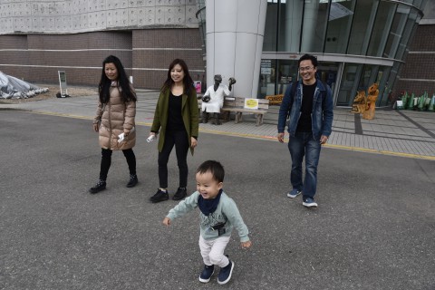 Mr. Ugyen Dorji and his son, wife and siter are walking outside of the dinosaur museum in Fukui